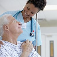 Provider smiling at a patient in a wheelchair